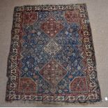 A 19th century Hamadan rug with three central conjoined lozenge shaped medallions with a device