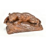 An early 19th century treacle glazed figure of a lioness upon a rock, unmarked, length 24cm.