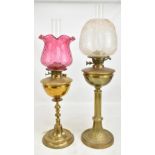 Two late 19th/early 20th century brass oil lamps, the first with foliate moulded and etched shade on
