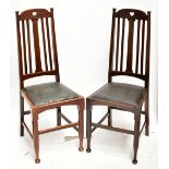 A set of four Arts & Crafts dining chairs with pierced hearts above slatted back panels and green