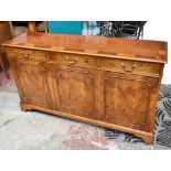 A reproduction yew wood sideboard with crossbanded top above three short drawers and three