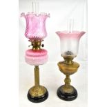 A Victorian oil lamp with a later cranberry glass shade and milk and cranberry glass reservoir,