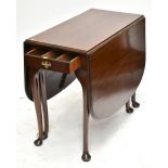 An early 20th century mahogany drop leaf dining table with single end drawer raised on cabriole