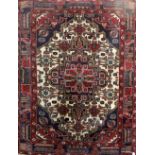 A Turkish blue ground woollen rug with central geometric lozenge surrounded by stepped border,