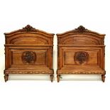 A Victorian walnut bedroom suite with carved floral decoration comprising a pair of single beds,