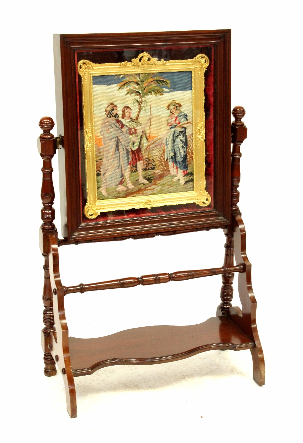 An Edwardian mahogany swing easel, the top enclosing a tapestried picture in a gilt frame,