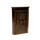 A 17th century style carved oak corner cupboard,