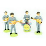 A set of four plaster figures of the Beatles, hand painted on circular bases, stickers to bases,