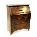 An oak fall-front bureau with interior pigeonholes over three long drawers, height 102cm.