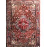 A Turkish red ground rug with central geometric lozenge surrounded by stepped border, 144 x 102cm.