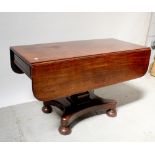 A 19th century mahogany dropleaf dining table on square tapered column to quatrefoil base raised on