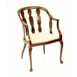 An Edwardian mahogany elbow chair with curved back and arms,