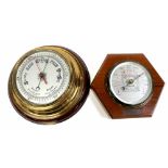 A 1930s oak hexagonal Stormguide barometer and a brass porthole-style barometer mounted on mahogany