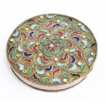 A Continental white metal and enamel compact of circular form with floral detail, the hinged cover