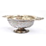 A late 19th century Dutch silver twin handled brandy bowl with beaded detail above repoussé panels