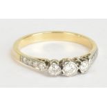 A yellow metal three stone diamond ring, size N 1/2, approx 2.6g.