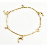 A yellow metal Figaro link bracelet suspending three dolphin charms, stamped 'CH 18K', length