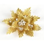 A yellow metal and diamond floral brooch, inset with ten diamonds, stamped 750 verso, approx 16.4g.