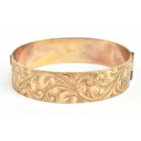 A 9ct yellow gold hinged bangle with chased detail to the front, internal diameter 5.7cm, approx