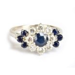 An 18ct white gold diamond and sapphire floral set ring, the central sapphire weighing approx 0.