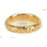 An 18ct yellow gold wedding band, with floral banded decoration, size K, approx 3.7g.Additional