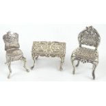 An Edward VII hallmarked silver miniature doll's house furniture table, with repoussé detail of