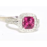 An 18ct white gold diamond and rubellite ring with pierced shoulders and raised platforms, size N,