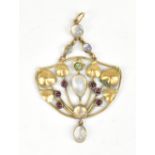 An Arts & Crafts/Art Nouveau 9ct gold moonstone and ruby pendant with stylised floral central