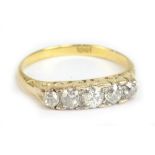 An 18ct yellow gold and diamond five stone ring, the central stone weighing approx 0.20cts in scroll