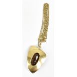 A 1970s abstract yellow metal pendant centred with a smoky quartz and suspended on a fine link