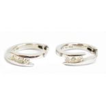 A pair of 9ct white gold diamond hoop earrings, each set with three small diamonds, diameter 1.