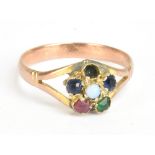 A yellow metal floral gem set ring centered with an opal within various coloured stones (one