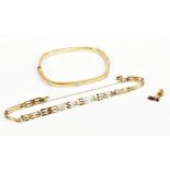A 9ct yellow gold bangle of rounded rectangular form with simulated screw heads, external