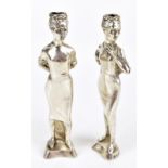 NAYLER BROS; two Elizabeth II hallmarked silver figural candle sticks, each modelled as elegant