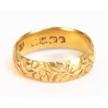 An 18ct yellow gold and floral engraved wedding band, size O, approx 4.8g.Additional InformationSome