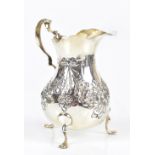 GEORGE NATHAN & RIDLEY HAYES; a hallmarked silver cream jug with embossed ribbon tied swags and