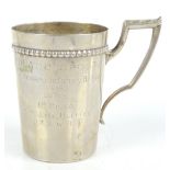 An early 20th century German silver cup with high square section looped handle and tapering body