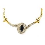 An 18ct yellow gold, diamond and sapphire necklace with scrolling pierced drop centred with an