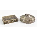 An Indian white metal snuff box of oval form with cast and filigree applied decoration, unmarked,