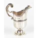MARTIN HALL & CO; a George V hallmarked silver helmet shaped cream jug, high loop handle and
