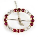 An 18ct yellow and white gold ruby and diamond brooch of oval form set with eight diamond