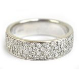 A 9ct white gold and pavé set diamond ring with the broad band containing four rows of diamonds,