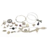 A quantity of silver costume jewellery including bangles, charm bracelet, brooch, loose charms,