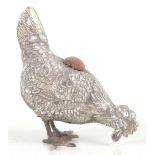 A Continental white metal pin cushion modelled in the form of a cockerel, with cast detail,