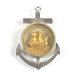 A late 19th century white metal naval fob in the form of an anchor with circular glass panel with