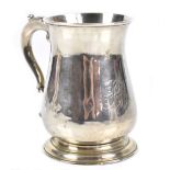 A George III hallmarked silver mug of baluster form with scrolling loop handle engraved initials