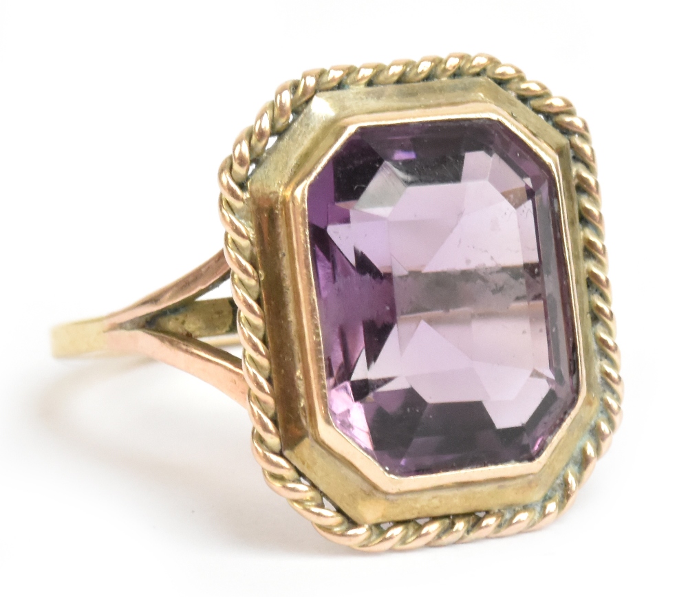 A yellow metal and amethyst dress ring, the faceted rectangular cut stone weighing approx 7.5cts, in