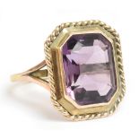 A yellow metal and amethyst dress ring, the faceted rectangular cut stone weighing approx 7.5cts, in