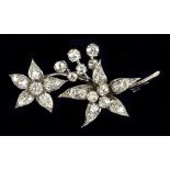 A white metal and diamond set floral brooch with two five petal sprays, unmarked, length 4.75cm,