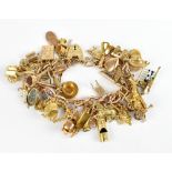 A 9ct yellow gold charm bracelet, set with multiple charms including abacus, kettle, letterbox,